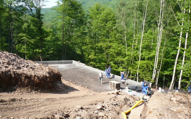 Opěrná zeď vyrovnávající strmý terén stanice lanové dráhy sjezdovky v Klínech