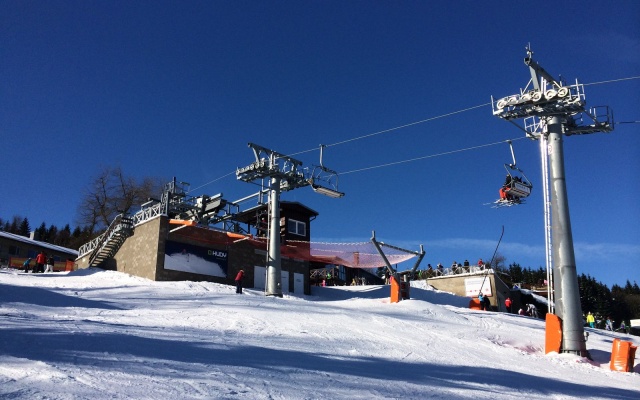 Opěrná zeď vyrovnávající strmý terén stanice lanové dráhy sjezdovky v Klínech