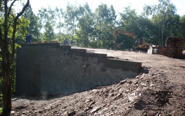 Opěrná zeď vyrovnávající strmý terén stanice lanové dráhy sjezdovky v Klínech