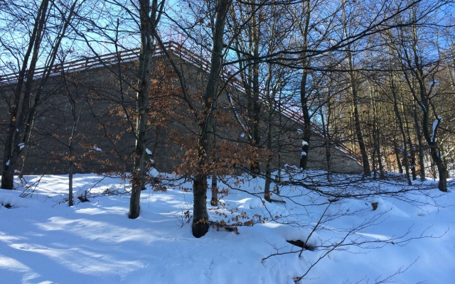 Opěrná zeď vyrovnávající strmý terén stanice lanové dráhy sjezdovky v Klínech