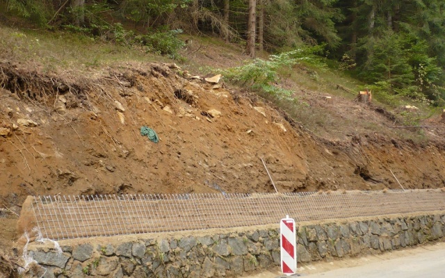 Výškové oddělení silnice a cyklostezky strmým svahem v Prášilech na Šumavě