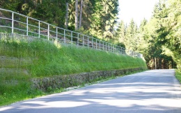 Výškové oddělení silnice a cyklostezky strmým svahem v Prášilech na Šumavě