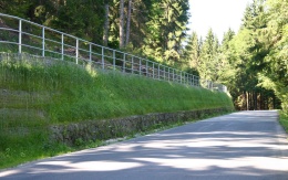 Výškové oddělení silnice a cyklostezky strmým svahem v Prášilech na Šumavě